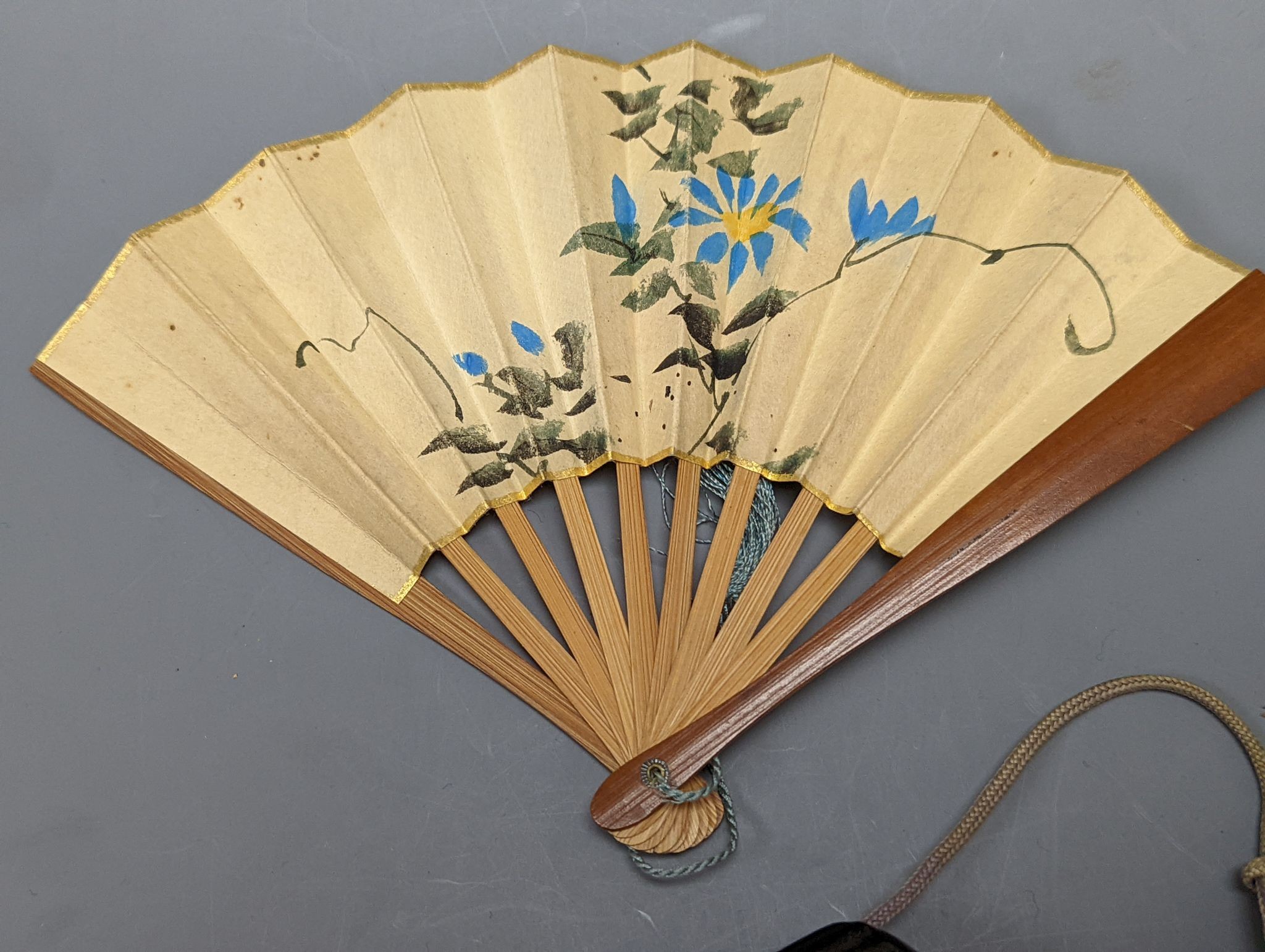 A 19th century Japanese lacquer three-case inro and a small Japanese woodblock printed fan with bamboo guards, 12cm